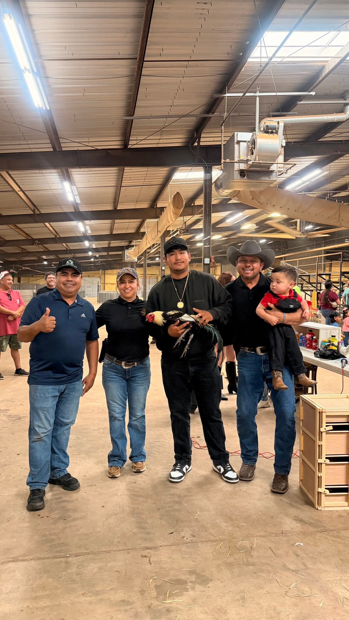 Three Roots community members with exhibition birds at a stock-show venue