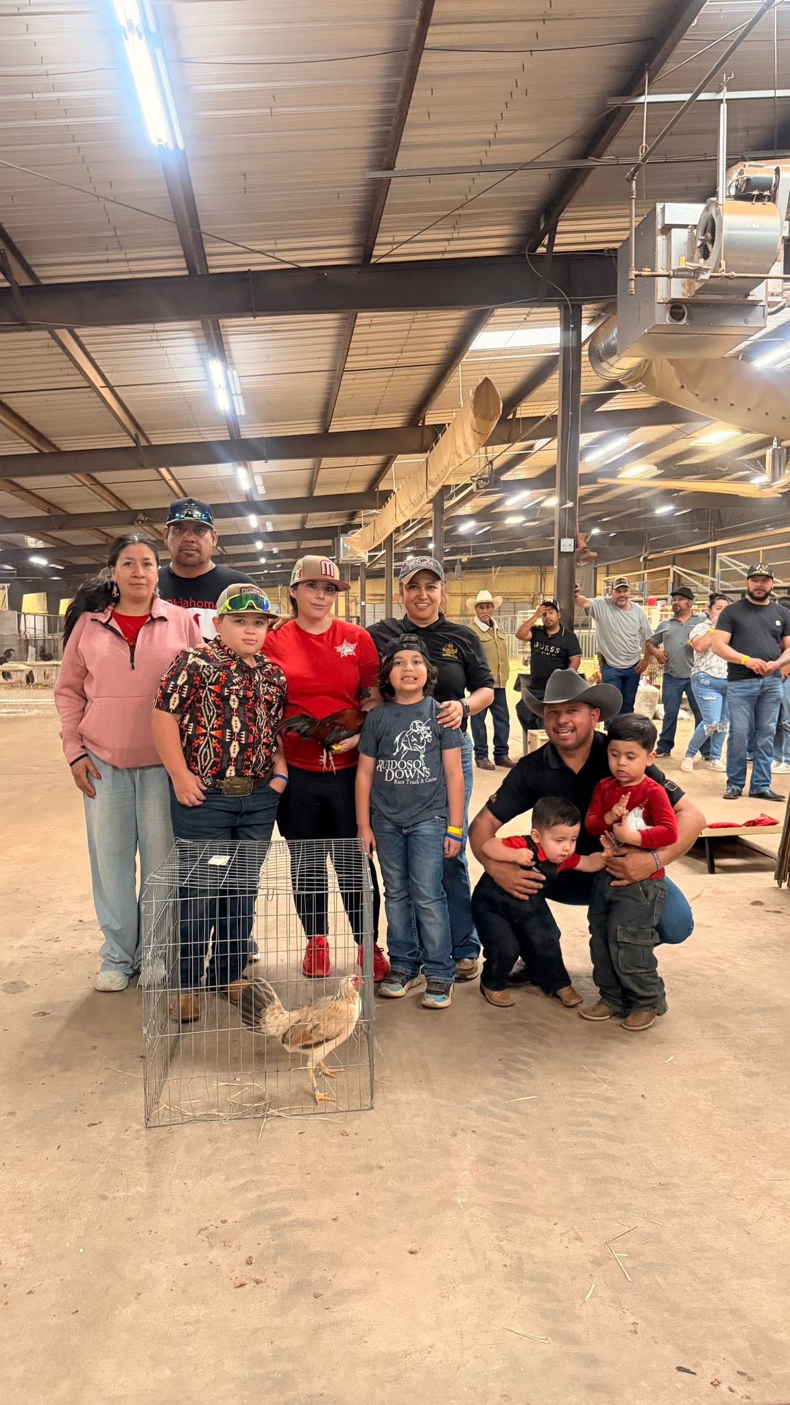 Three Roots community members with exhibition birds at a stock-show venue